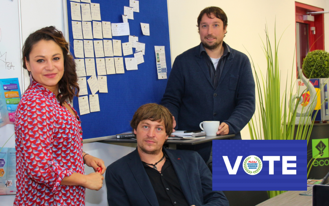 Three CONDUU team members in office with a visible “VOTE” sign for the FLCAJ Readers' Choice Award.